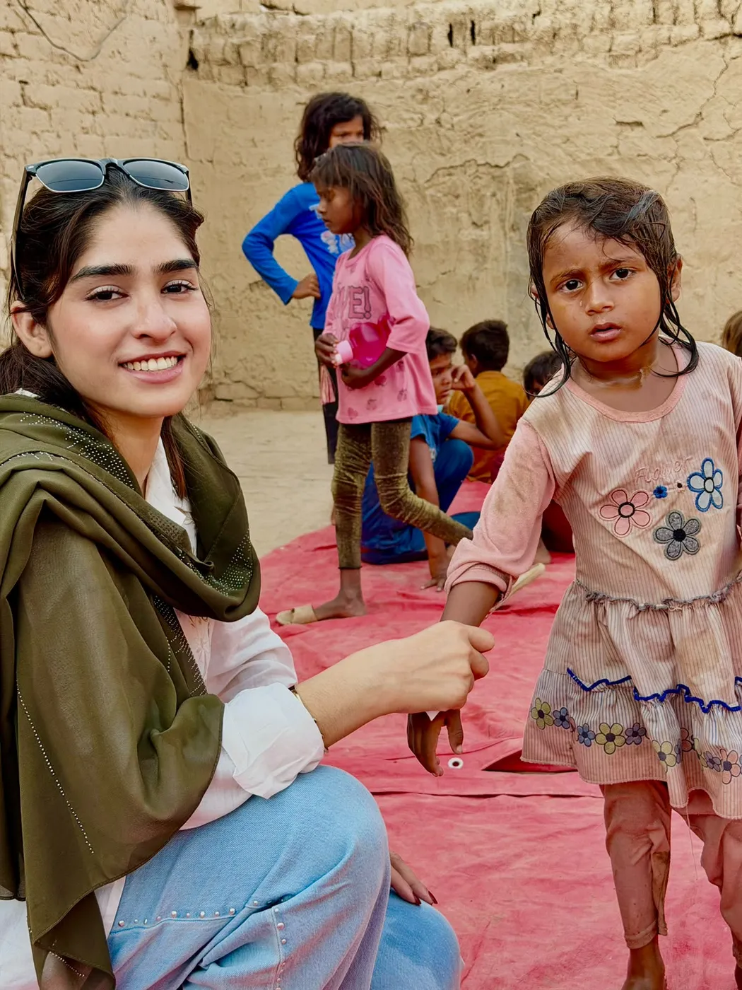 A woman sitting beside a young child and holding her hand