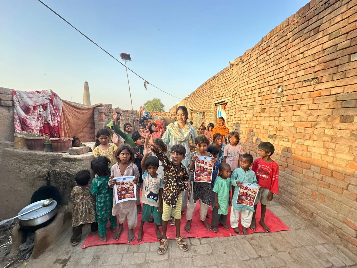 A woman and a group of children gathered in a brick courtyard